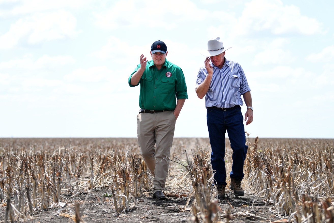 Prime Minister Scott Morrison (left) chats to farmer David Gooding on a recent trip to Queensland. Morrison said increasing the threshold for asset tax write-offs would help employers, including primary producers in Queensland, buy equipment. (Photo: AAP Image/Dan Peled)