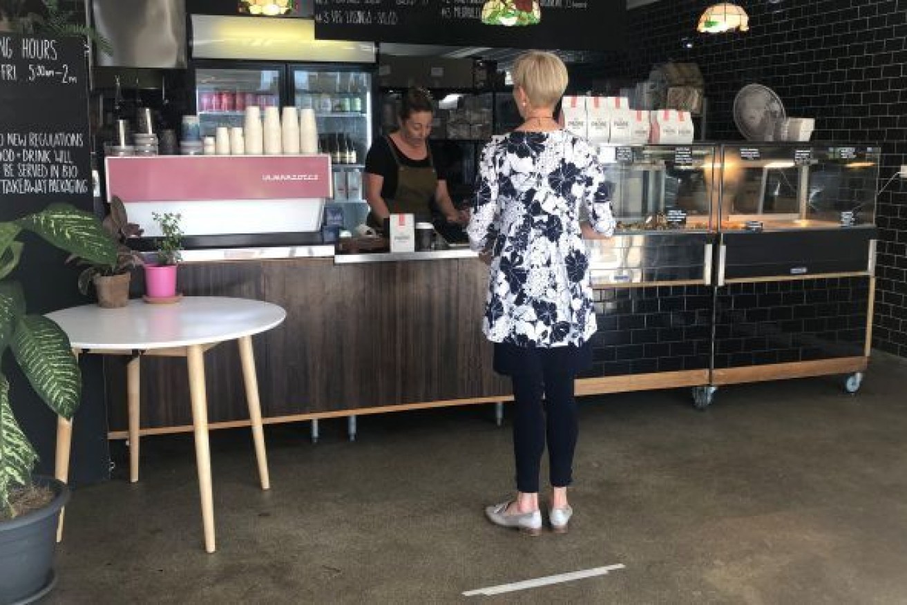 Cafes are adhering to social distancing requirement, places markers on the floor to show people how far apart to stand. (Photo: ABC)