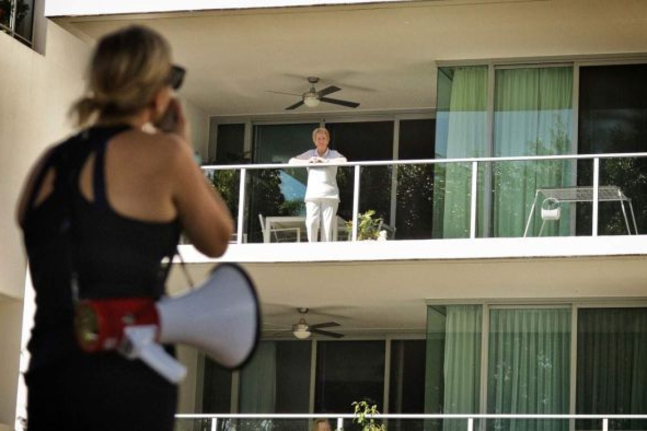 A fitness instructor uses a megaphone to help demonstrate exercises in a park to residents. Photo: ABC