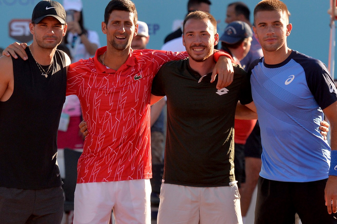 In this photo taken June 19, 2020, Serbian tennis player Novak Djokovic, second left, poses with Bulgaria's Grigor Dimitrov, left, Serbia's Viktor Troicki and Croatia's Borna Coric, right, at a tournament in Zadar, Croatia. Novak Djokovic has tested positive for the coronavirus after taking part in a tennis exhibition series he organized in Serbia and Croatia. (AP Photo/Zvonko Kucelin)