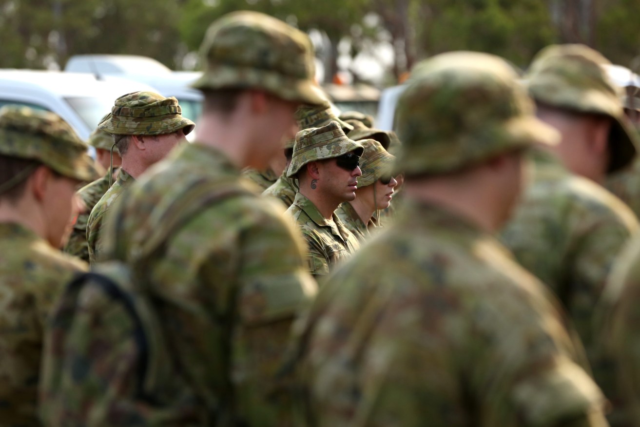 Australian Army Reserve and Regular personnel are seen during a roll call ahead of departing the Holsworthy Barracks. More than 500 ADF staff will be deployed to the NSW-Victorian border (AAP Image/Danny Casey)