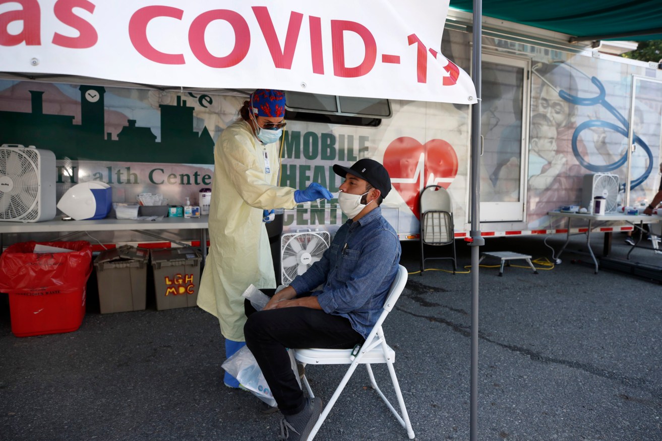 Nurse Tanya Markos administers a coronavirus test on patient Ricardo Sojuel at a mobile COVID-19 testing unit, in Lawrence, Massachusetts. (AP Photo/Elise Amendola)