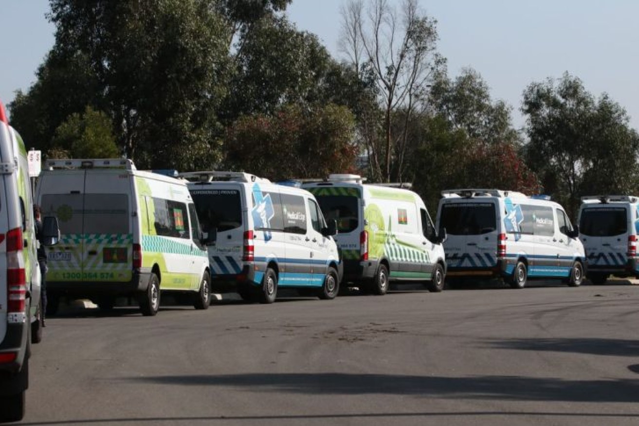 Patient transport vans parked outside Epping Gardens aged care home in Melbourne's north on Wednesday, as authorities prepared to transport several residents infected with coronavirus to hospital. (Photo: ABC News)