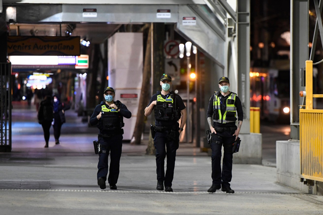 Protective Service Officers patrol Swanston street before a citywide curfew is introduced in Melbourne on Sunday. (Photo: AAP Image/Erik Anderson) 
