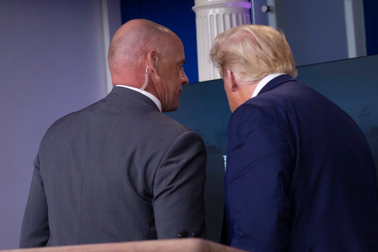 US President Donald Trump is removed from the White House Briefing Room by a US Secret Service agent during a press conference in Washington.  (Photo: EPA/Stefani Reynolds / POOL)