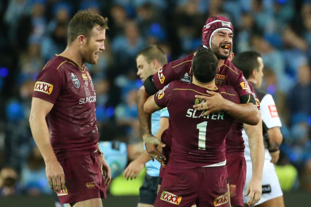 Johnathan Thurston of the Maroons is lifted up by team mate Billy Slater as they celebrate victory over the Blues. (AAP Image/David Moir) 