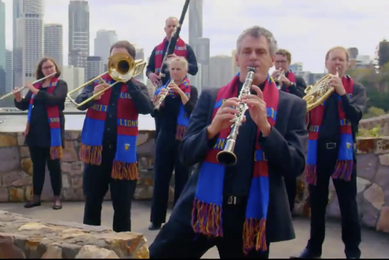 Queensland Symphony Orchestra musicians perform the Brisbane Lions team song at Kangaroo Point cliffs.