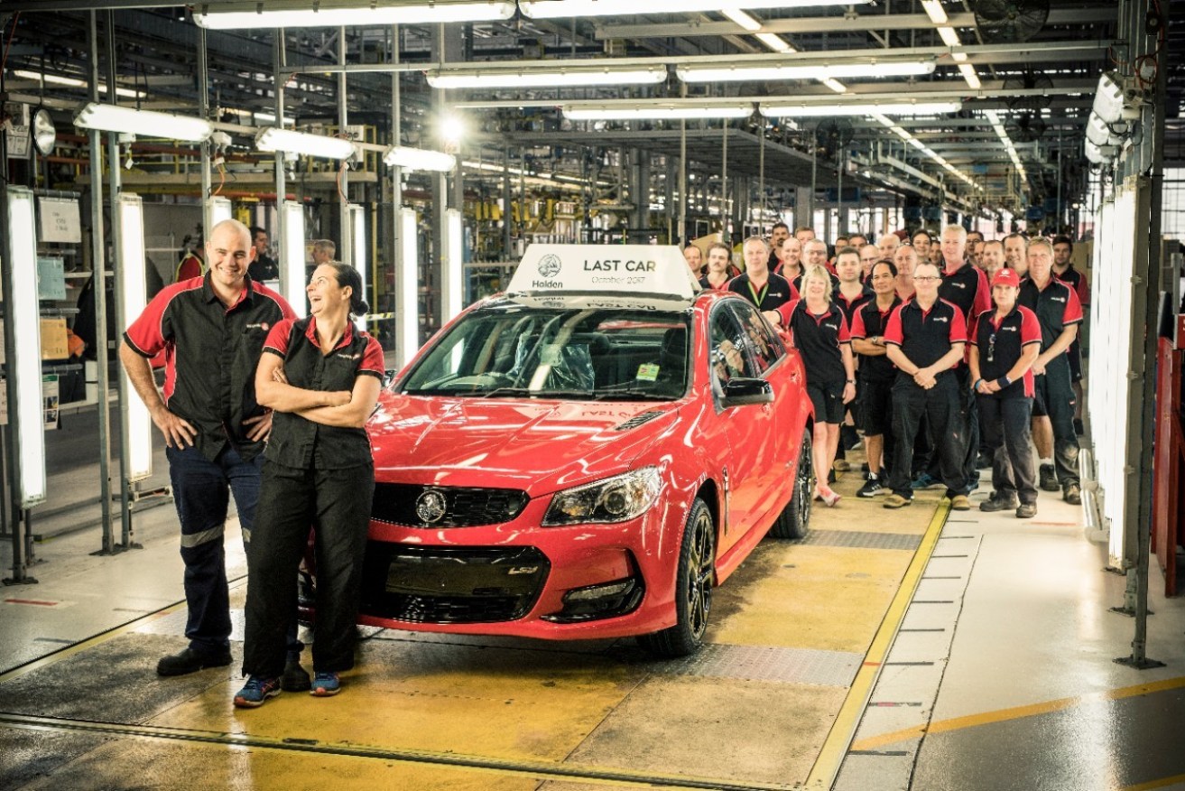 Staff pose for a photograph with the last vehicle to roll off the production line at the Holden plant in Elizabeth, Adelaide, in October 2017. (Photo: AAP Image/ Supplied by Holden Pressroom)