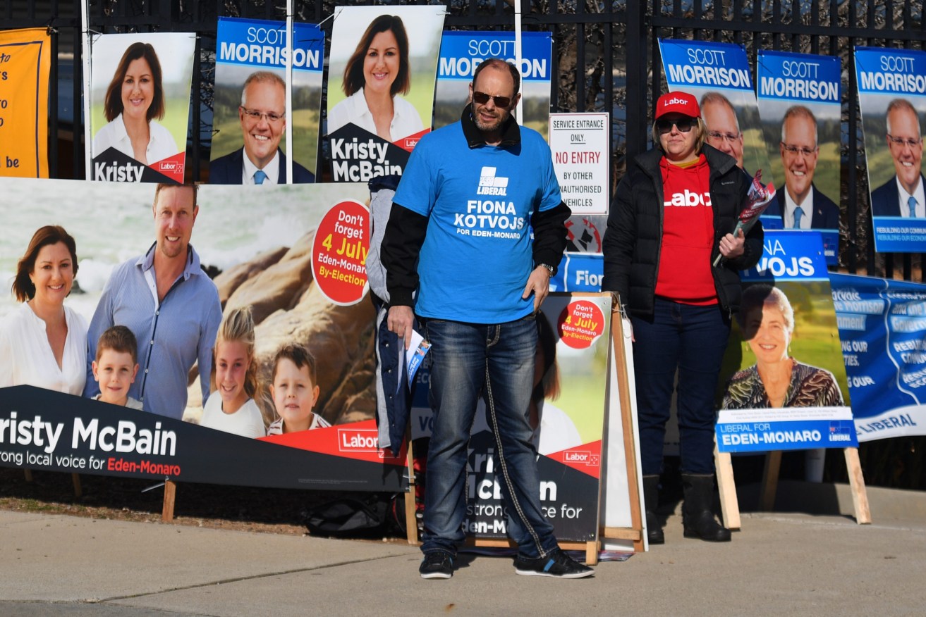 Volunteers with campaign posters are a familiar sight on our footpaths at election time. (Photo: AAP Image/Mick Tsikas) 