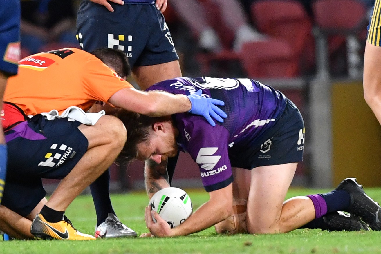 Cameron Munster of the Storm receives assistance after sustaining an injury during the second NRL Qualifying Final . (AAP Image/Darren England) 