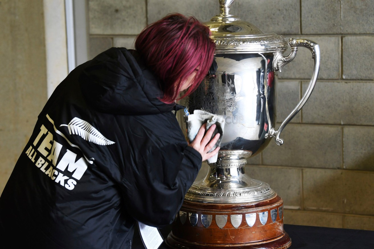 A staff member polishes the Bledisloe Cup ahead of the rugby game between the All Blacks and the Wallabies in Wellington. (Andrew Cornaga/Photosport via AP)