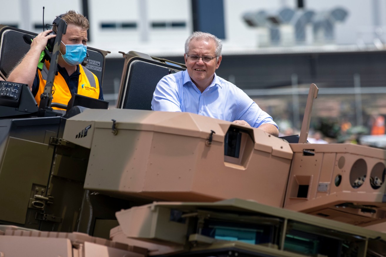 Prime Minister Scott Morrison takes a ride in a Combat Reconnaissance Vehicle during the opening of Rheinmetall Military Vehicle Centre of Excellence in Redbank, Queensland on Sunday. (Photo: AAP Image/Glenn Hunt) 