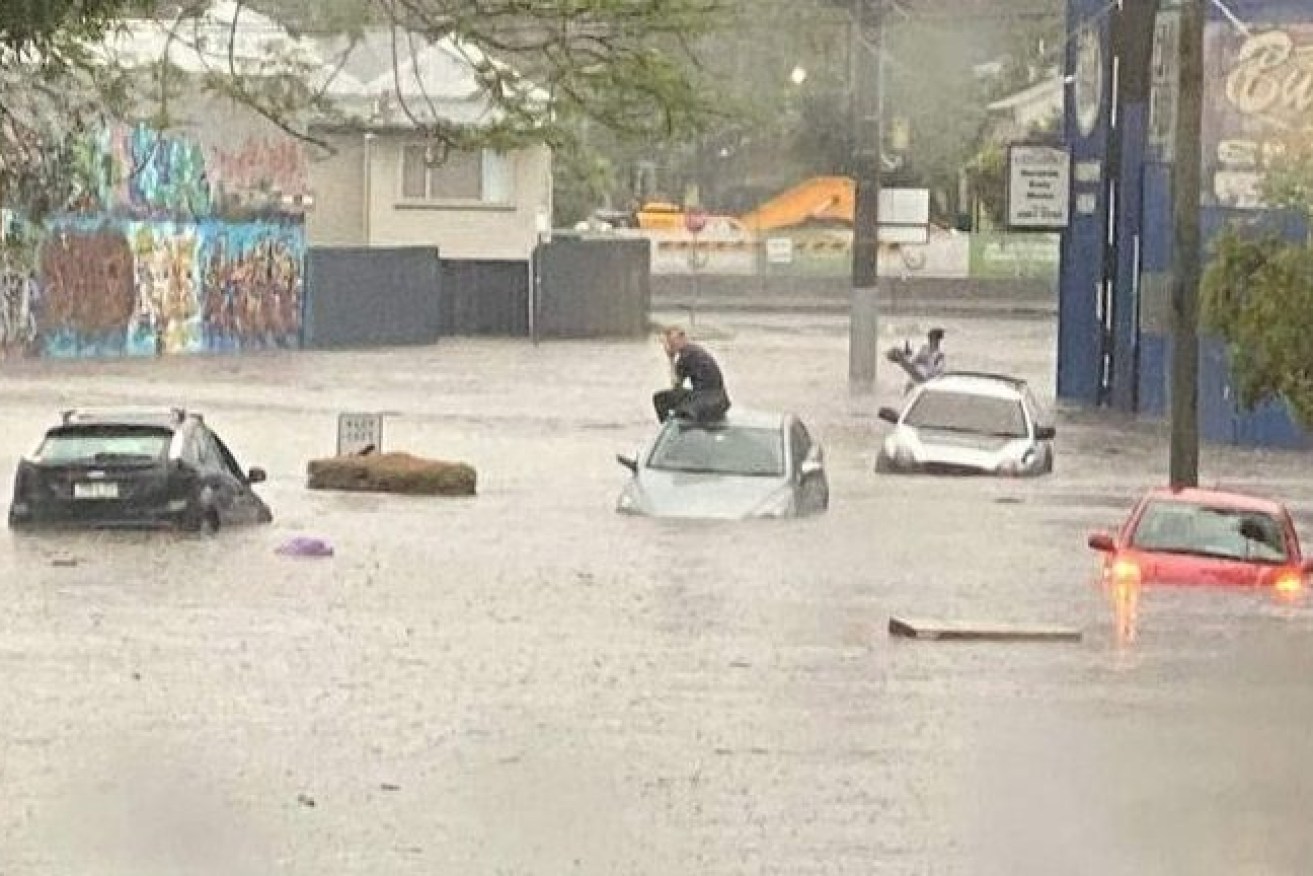 A man on top of his car trapped in flash flooding last week in Longlands Street in East Brisbane. (Photo: Supplied)