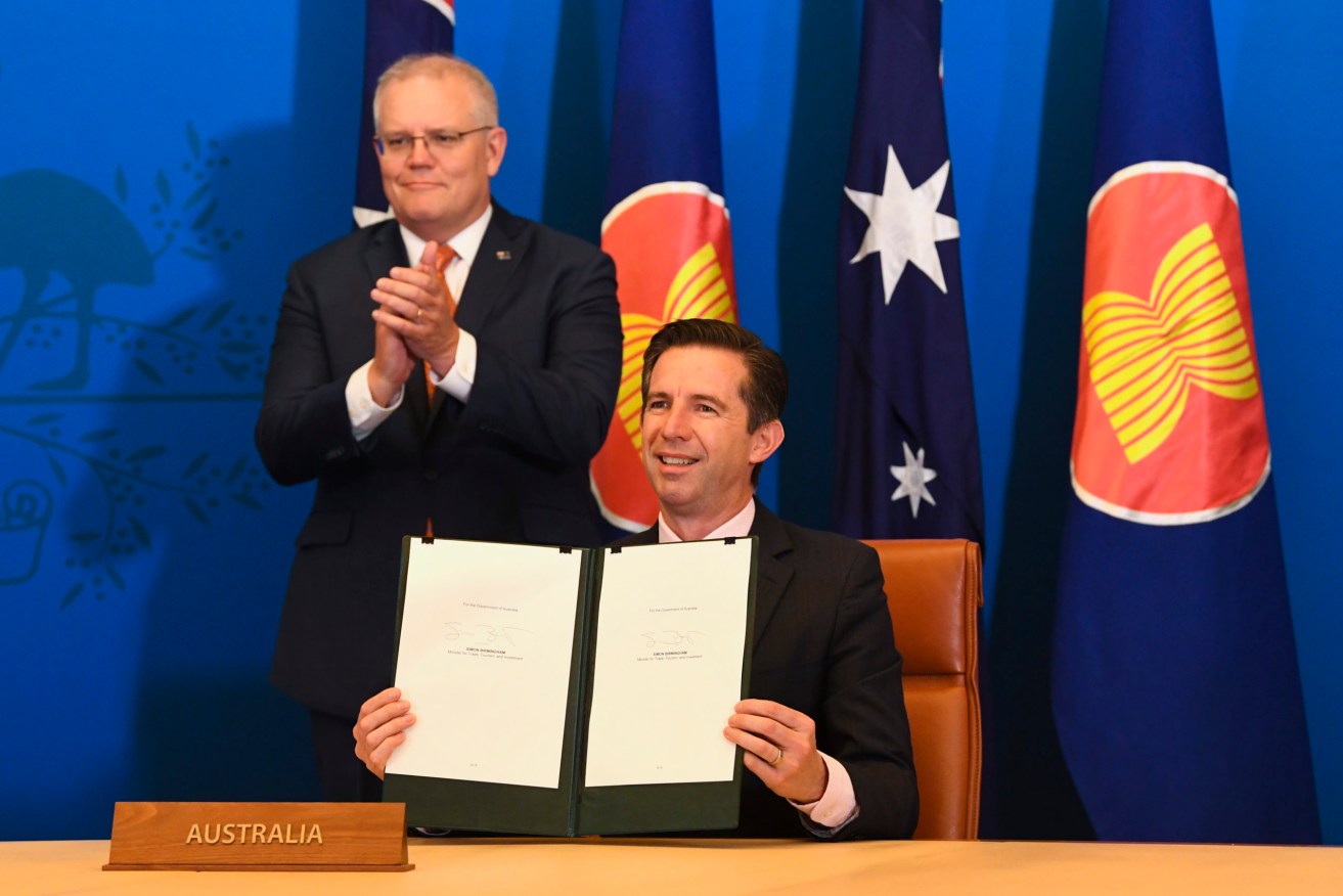 Australian Trade Minister Simon Birmingham (front) and Australian Prime Minister Scott Morrison react after signing the Regional Comprehensive Economic Partnership (RCEP) during a virtual signing ceremony at Parliament House. (Photo: AAP Image/Lukas Coch) 