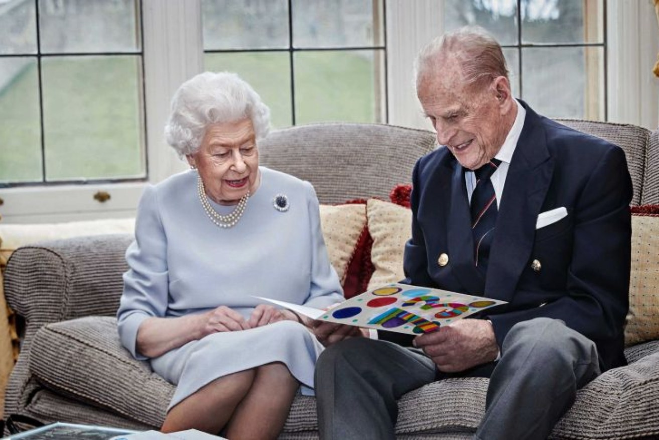Queen Elizabeth II and the Duke of Edinburgh look at a homemade wedding anniversary card, given to them by Prince George, Princess Charlotte and Prince Louis. (Photo: AP: Chris Jackson)