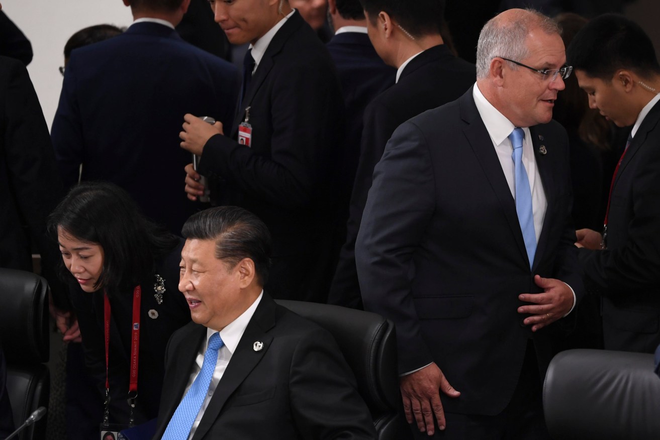 Australian Prime Minister Scott Morrison walks past Chinese President Xi Jingping during a Plenary Session at the G20 summit in Osaka, Japan. (Photo: AAP Image/Lukas Coch) 