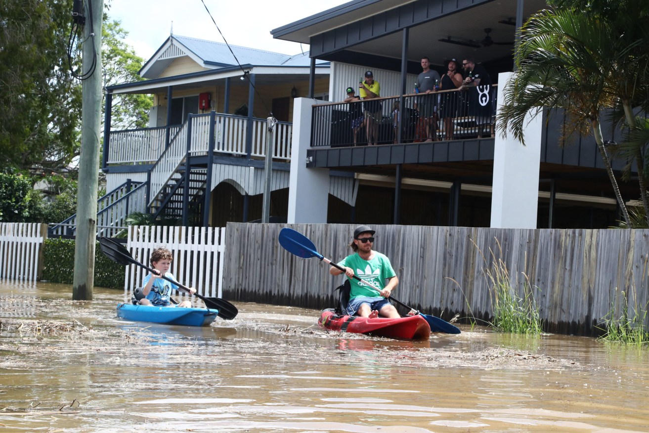 Residents of Tumbulgum paddle their kayaks down a street. The region around the northern NSW town of Murwillumbah has been declared 'a high danger area' by the SES, with people there ordered to evacuate. (Photo: AAP Image/Jason O'Brien) 