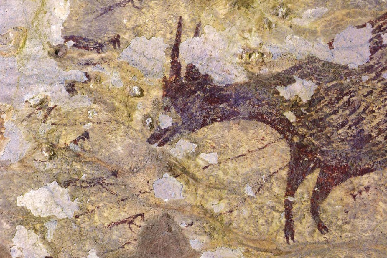 The painting portrays a group of part-human, part-animal figures hunting large mammals with spears or ropes. Photo: Griffith University