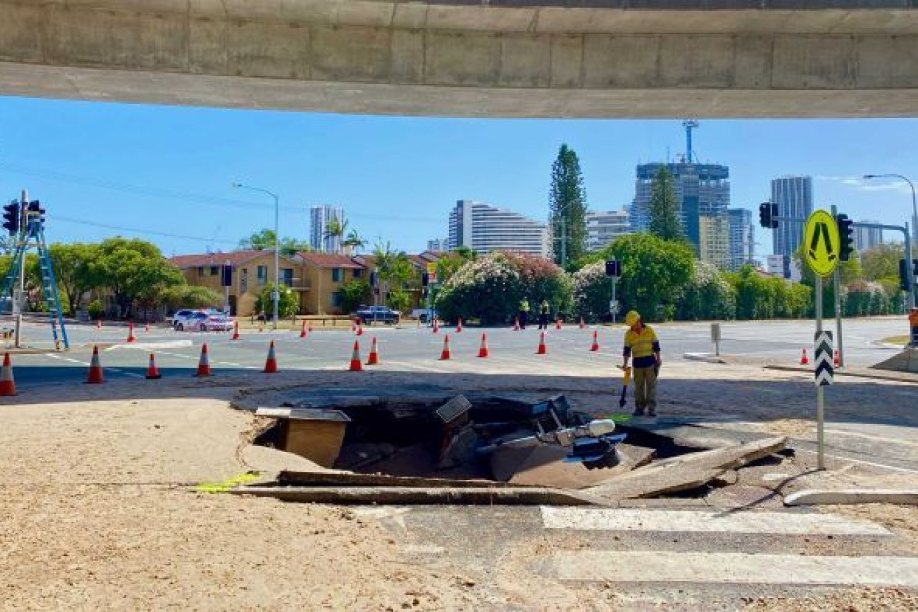 A large sinkhole has swallowed traffic lights on a busy intersection near Pacific Fair Shopping Centre on the Gold Coast. (Photo: ABC)