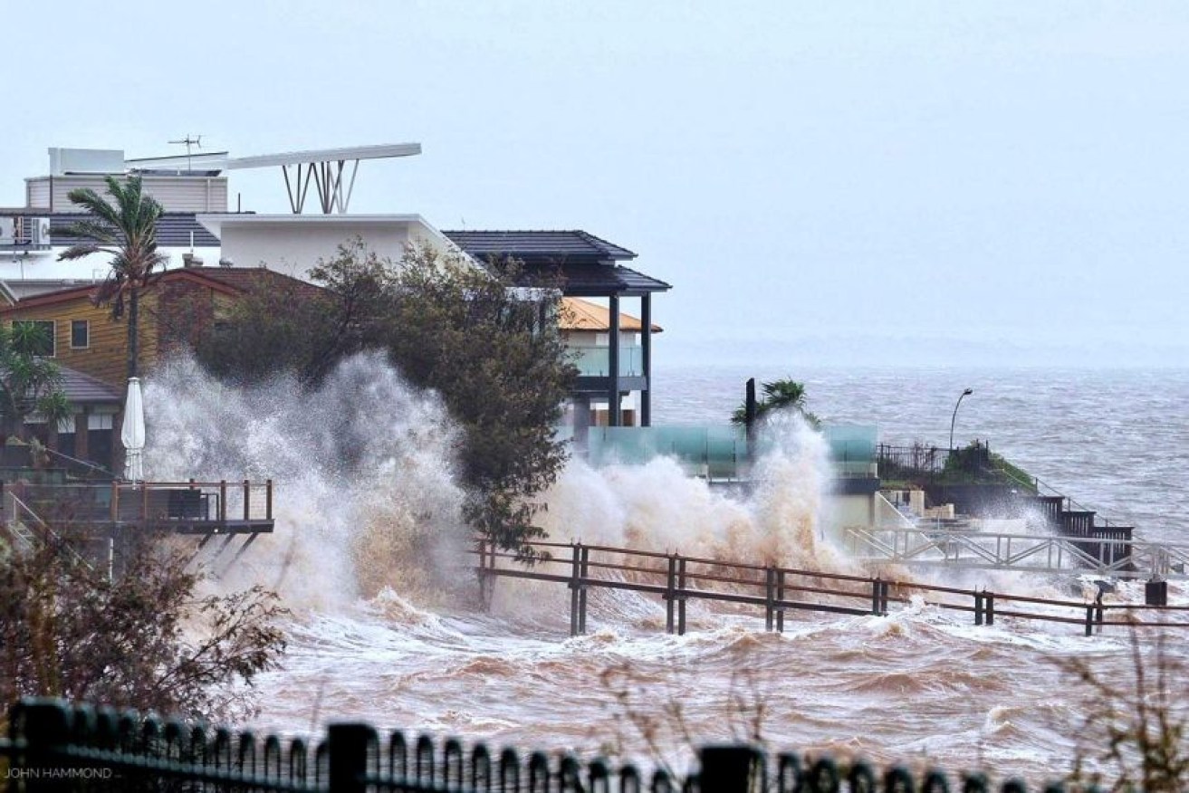 Waterfront homes at Scarborough in the Moreton Bay region are lashed by wild weather and big swells.Photo: ABC/John Hammond