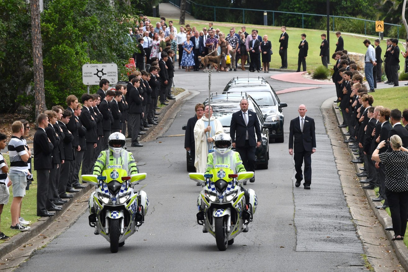Family and friends are seen as two hearses containing the coffins of Matt Field and Kate Leadbetter are given a guard of honour by students at Iona College in Brisbane on Monday. (AAP Image/Darren England)