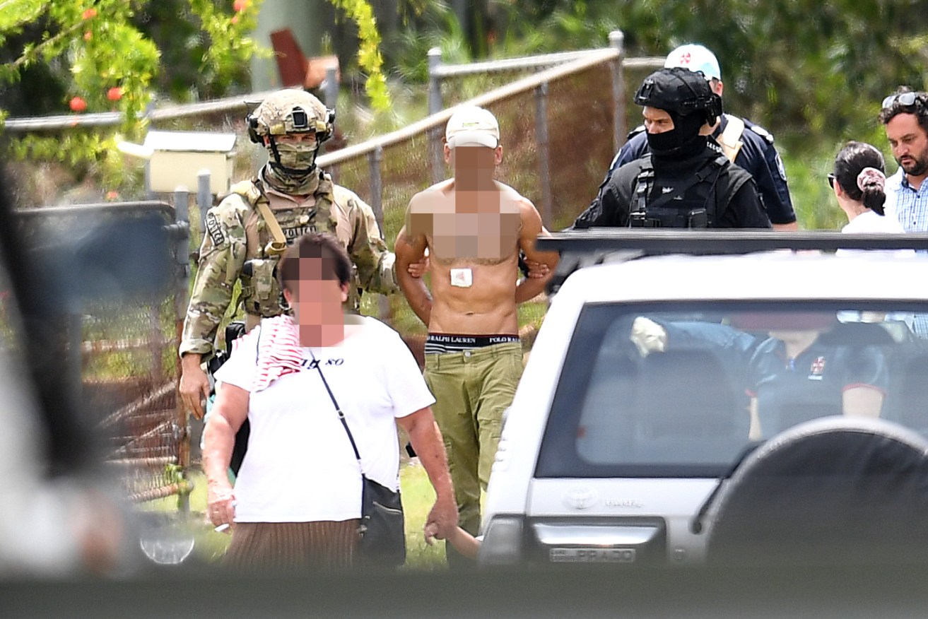 Police SERT team arrest a man, after an armed siege involving himself, a woman (pictured on left) and a child in Sunnybank. Photo: AAP/Dan Peled