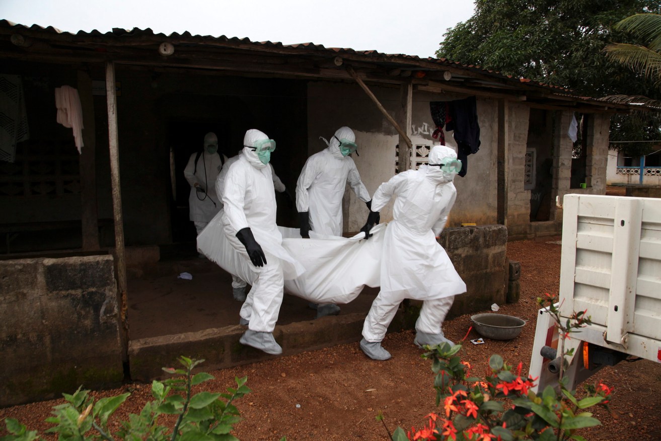 Liberian nurses carry the body of an Ebola victim from a house for burial in the Banjor Community on the outskirts of Monrovia, Liberia, in 2014. (Photo: EPA/AHMED JALLANZO)
