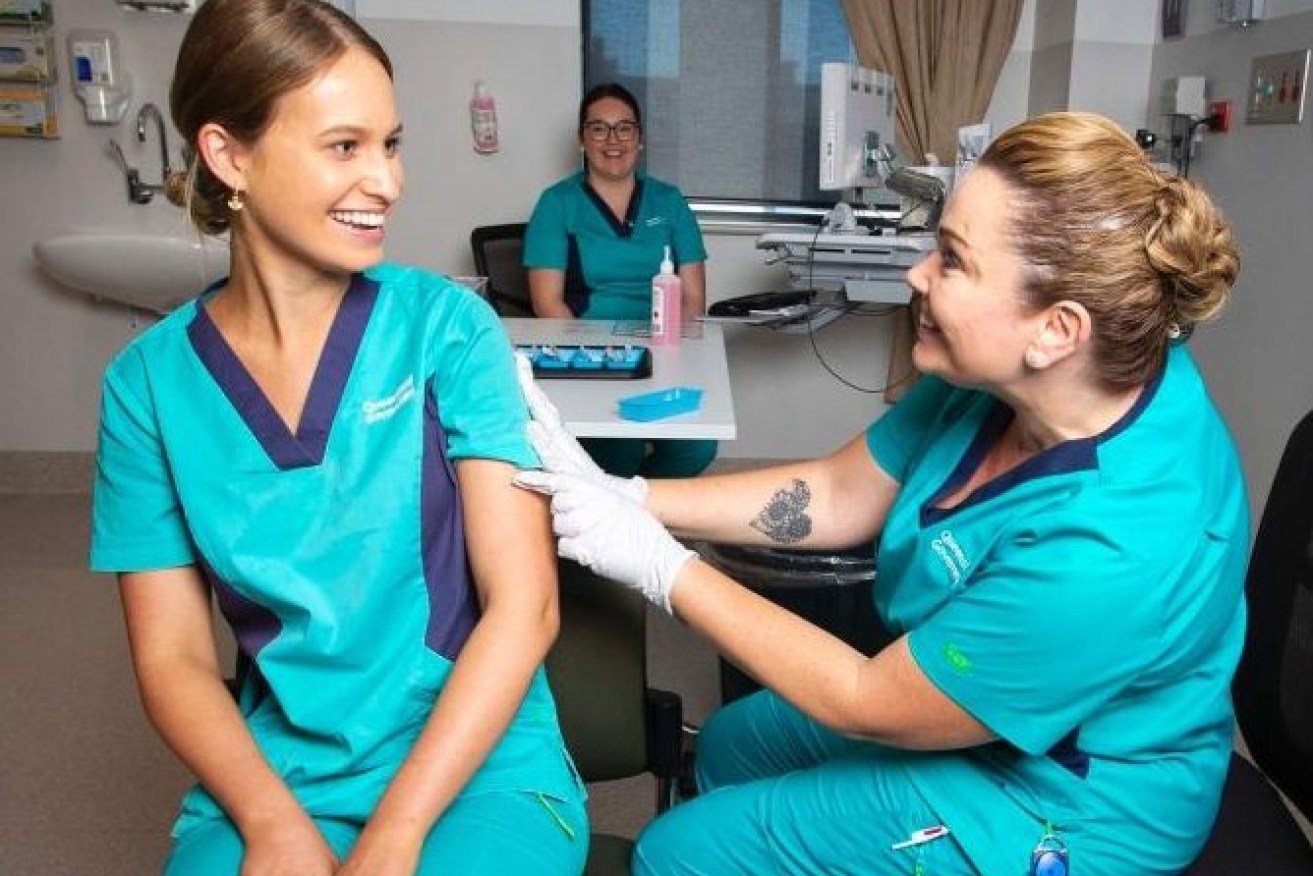 Nurse Zoe Park receives a Covid-19 vaccine jab at the Gold Coast University Hospital. (AAP: Nigel Hallett)