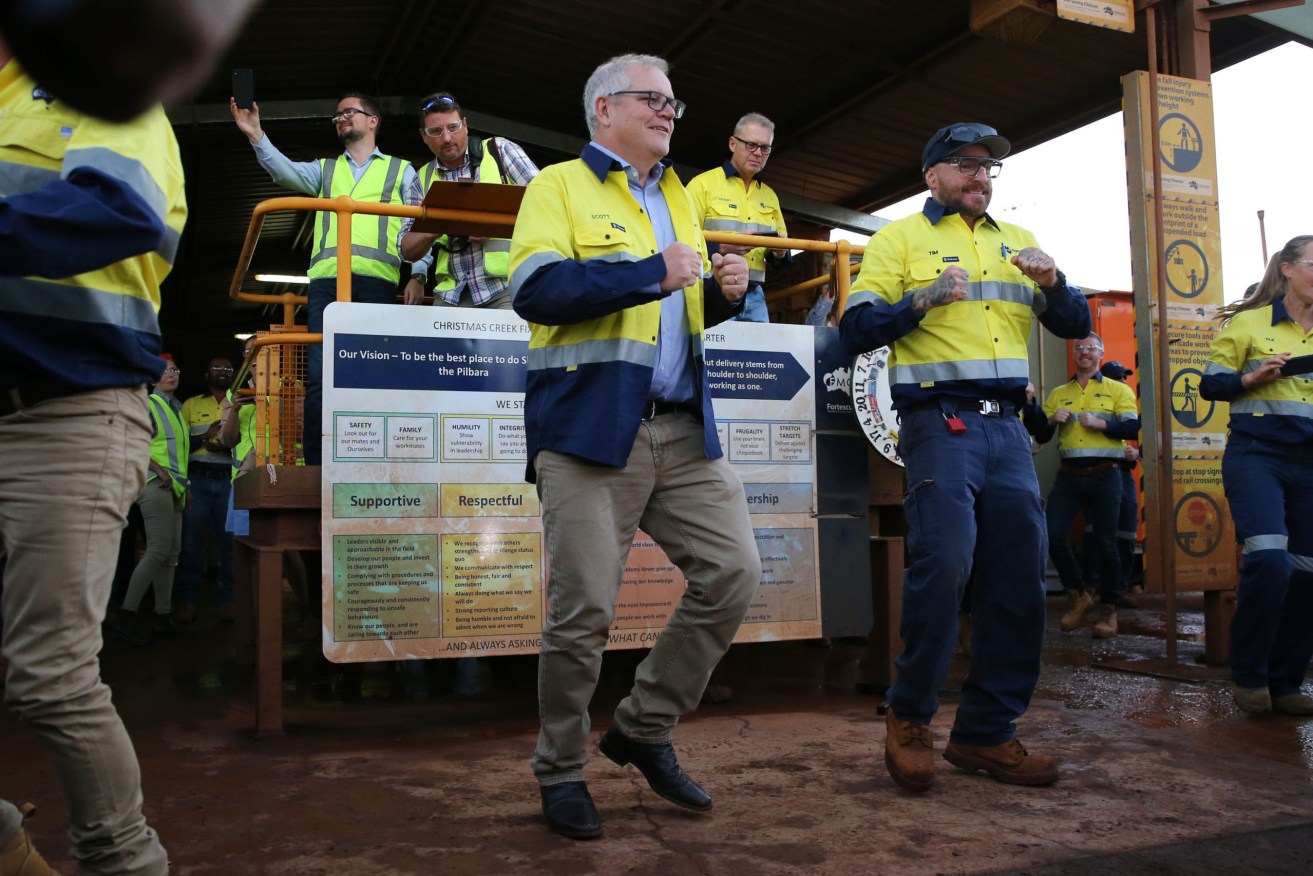 Prime Minister Scott Morrison and Fortescue Metals chairman Andrew Forrest join workers for morning exercise during a visit to the Christmas Creek mine site in The Pilbara, Western Australia. (AAP Image/Pool, Justin Benson-Cooper) 