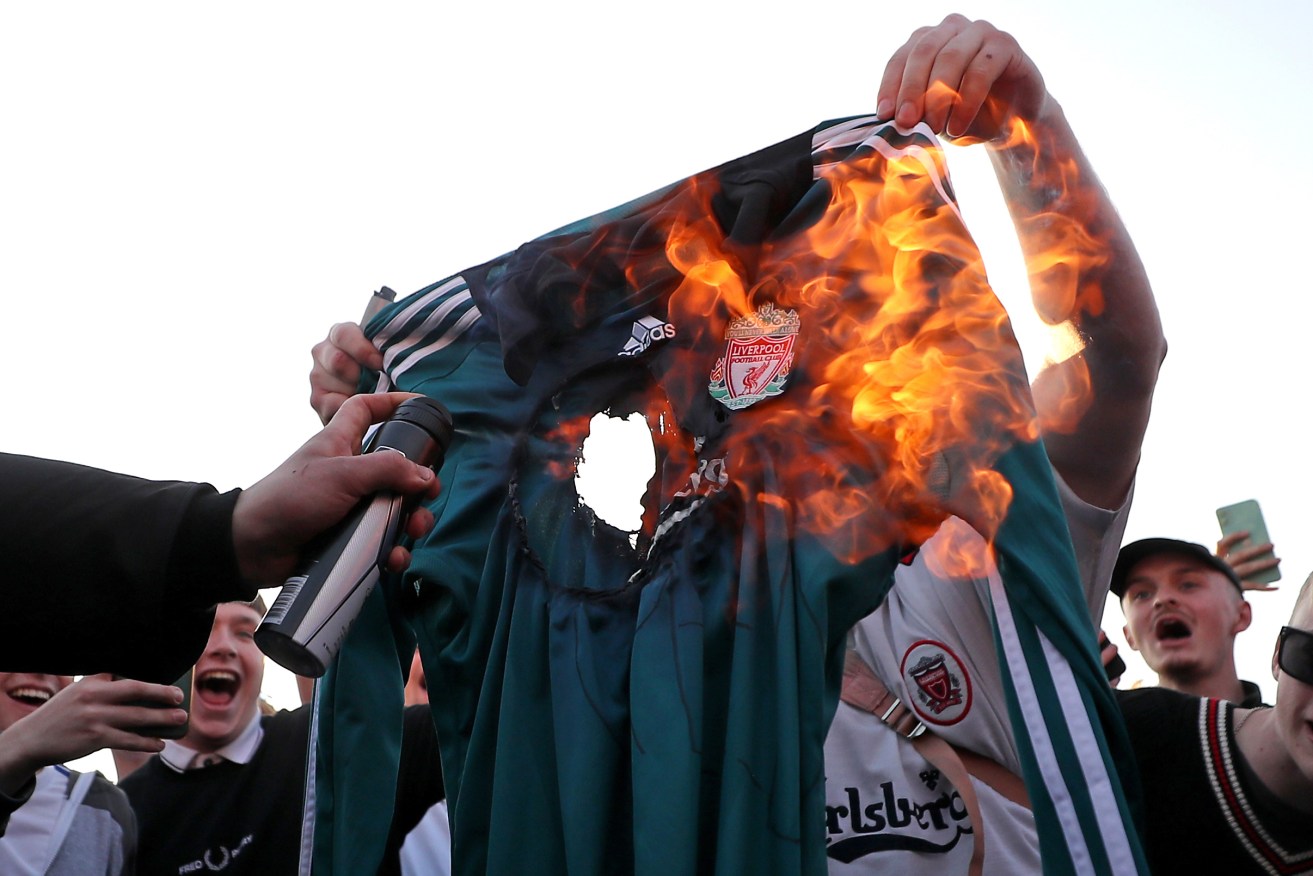 Fans burn a Liverpool replica shirt outside Elland Road against Liverpool's decision to be included amongst the clubs attempting to form a new European Super League. ( Zac Goodwin/PA Wire.)