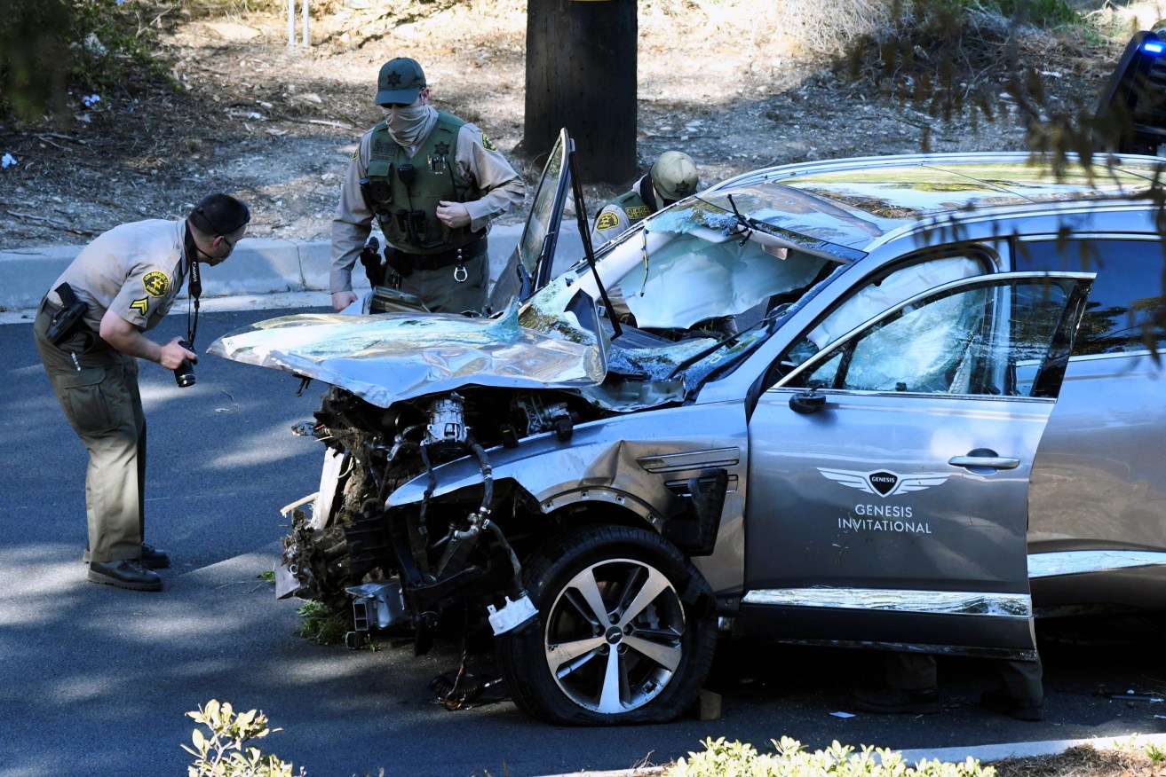 Los Angeles County Sheriff's Deputies inspect the vehicle of golfer Tiger Woods, who was involved in a single-vehicle accident in Los Angeles, California,  February 23. ( REUTERS/Gene Blevins)   