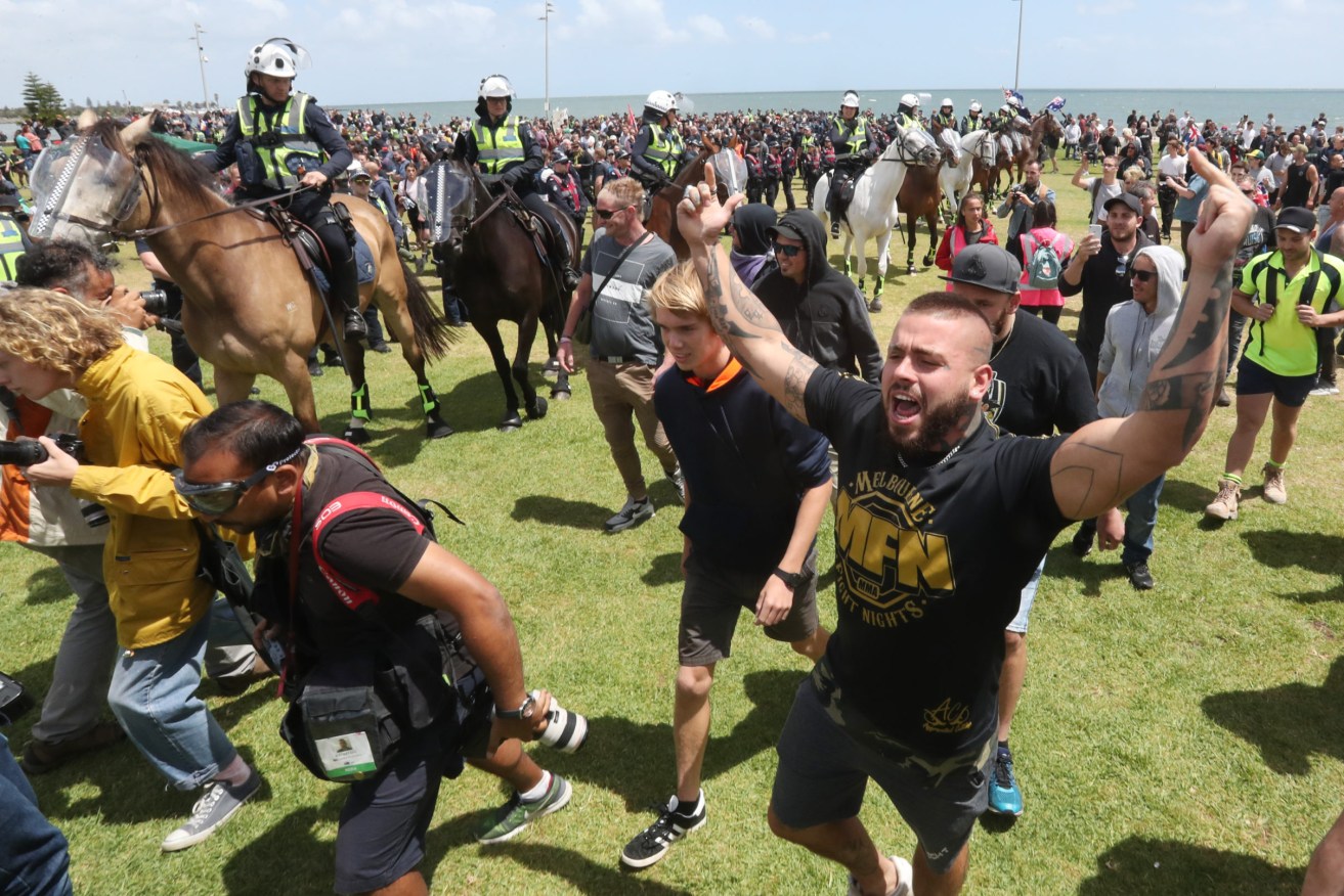 Police keep protesters apart on the St Kilda foreshore in Melbourne as far right wing activist Neil Erikson hosts "political meeting". A Parliamentary inquiry has warned that hate crimes and right-wing extremism is in the rise in Queensland.(AAP Image/David Crosling) 