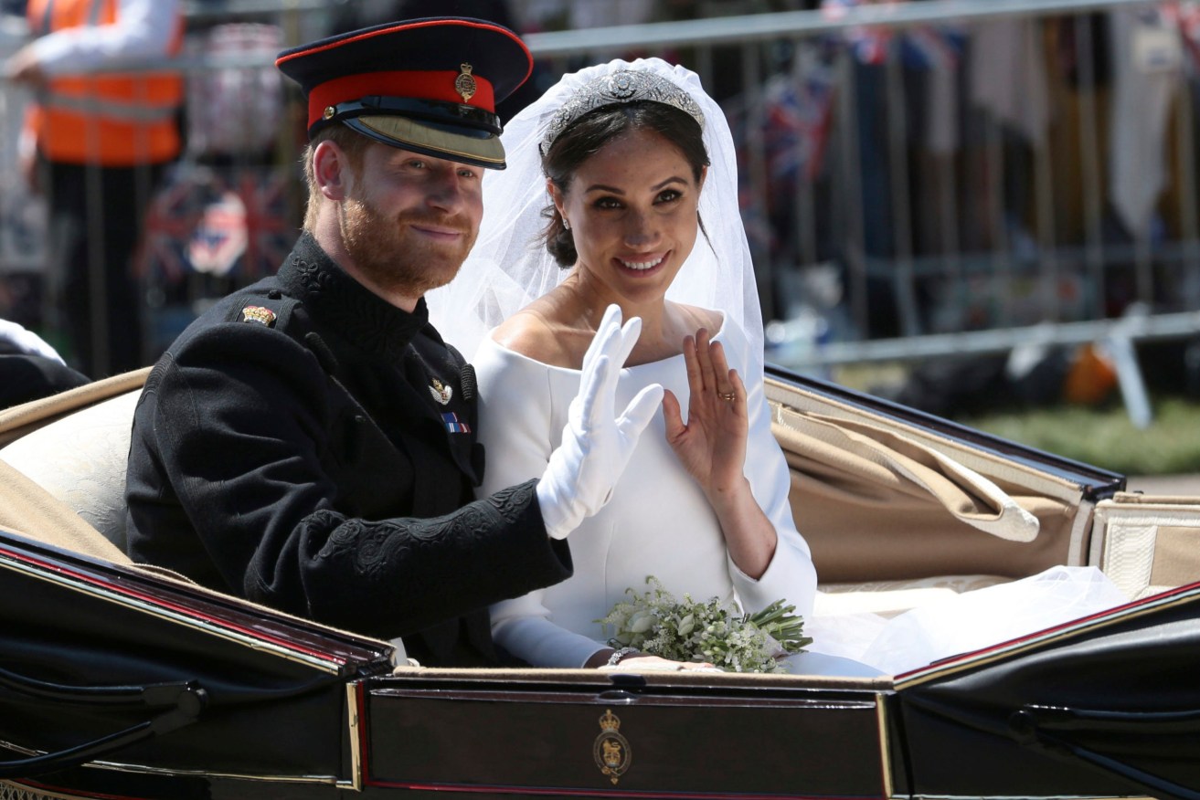Harry and Meghan ride in an open-topped carriage after their wedding ceremony. Photo via AP