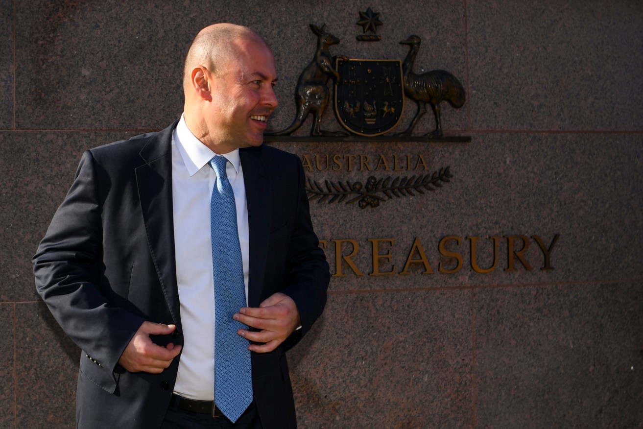 Australian Treasurer Josh Frydenberg poses for photographs outside the Treasury building in Canberra.  Frydenberg will hand down his third budget tomorrow. (AAP Image/Lukas Coch) 