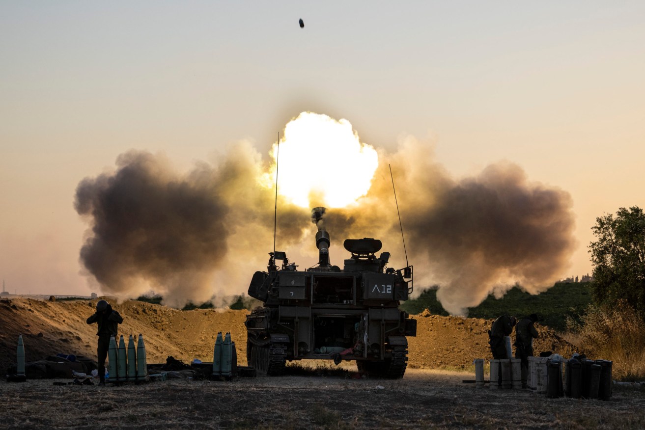 An Israeli artillery unit fires shells towards targets in Gaza Strip, at the Israeli Gaza border. (AP Photo/Tsafrir Abayov)