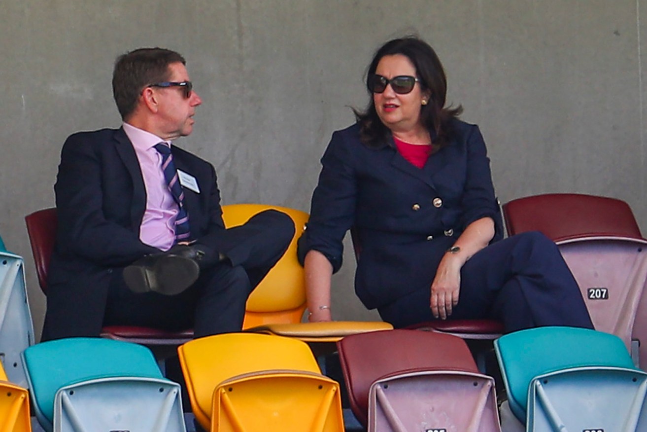 Are the Treasurer Cameron Dick and Premier Annastacia Palaszczuk searching behind chairs at The Gabba for more loose change? (AP Photo/Tertius Pickard)