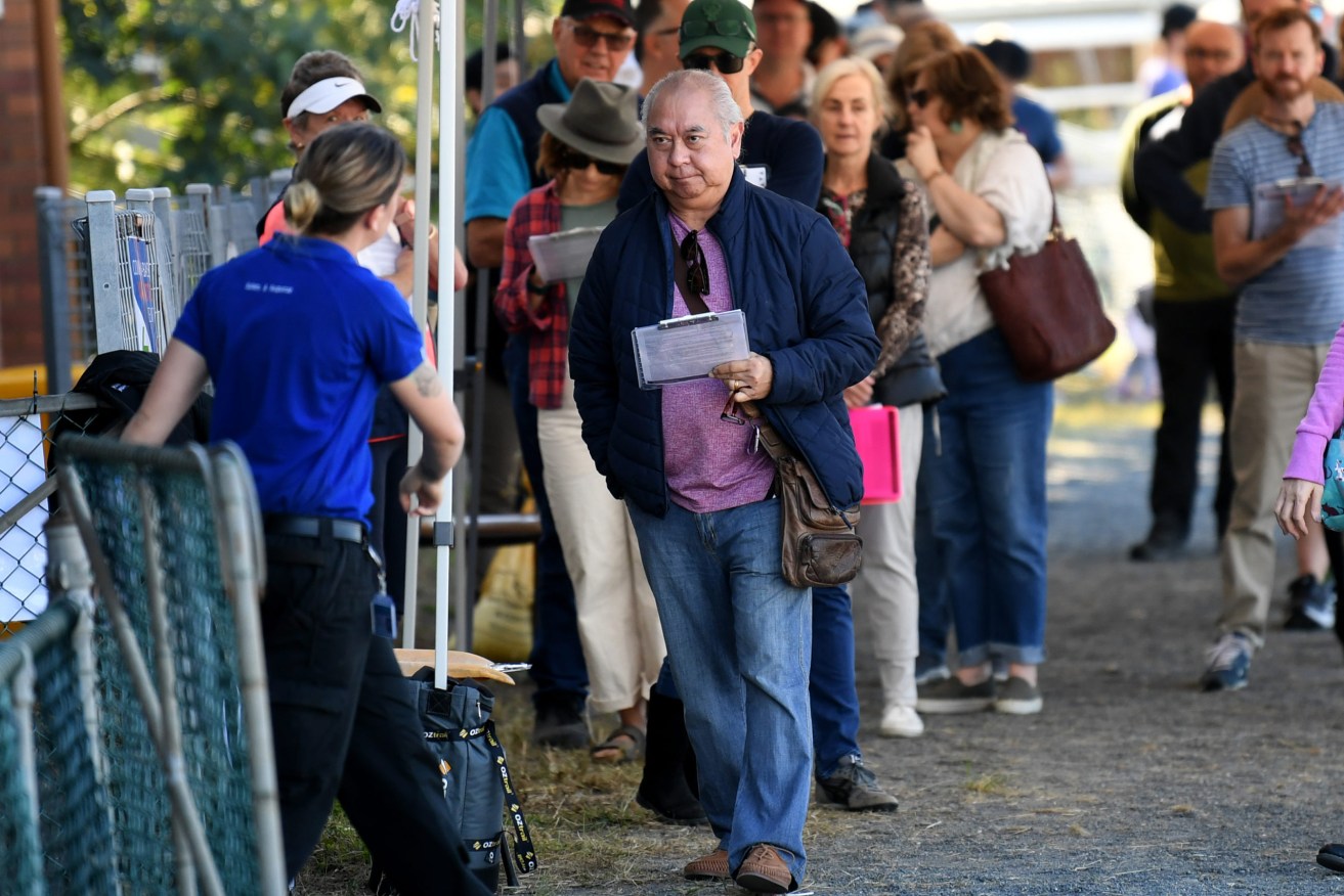 People line up to receive a coronavirus vaccination at the Rocklea Showgrounds, one of 18 hubs across the state. (AAP Image/Dan Peled) 