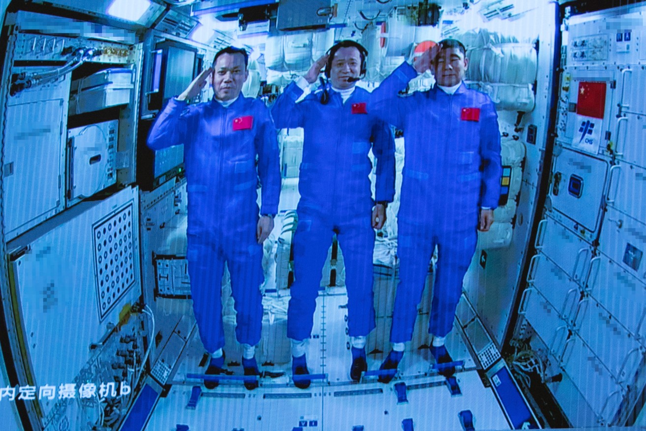 Chinese astronauts salute after successfully entering the Tianhe space station module as they are displayed on a big screen at the Beijing Aerospace Control Center. China has launched the first three-man crew to its new space station in its the ambitious programs first crewed mission in five years (Jin Liwang/Xinhua via AP)