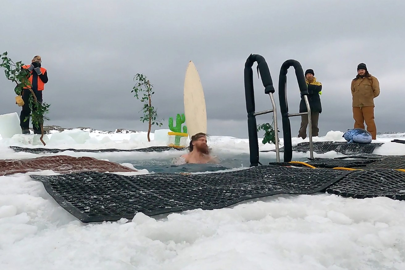 A supplied still image obtained on Sunday, June 20 shows an expeditioner at Australia's Casey research station in Antarctica plunging into an ice pool to mark the winter solstice.  (AAP Image/Supplied by Australian Antarctic Division) 
