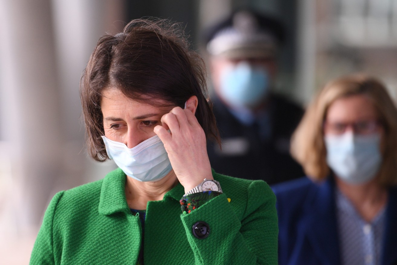 NSW Premier Gladys Berejiklian removes her face mask as she arrives to provide an update to the latest COVID-19 situation. (AAP Image/Dean Lewins)