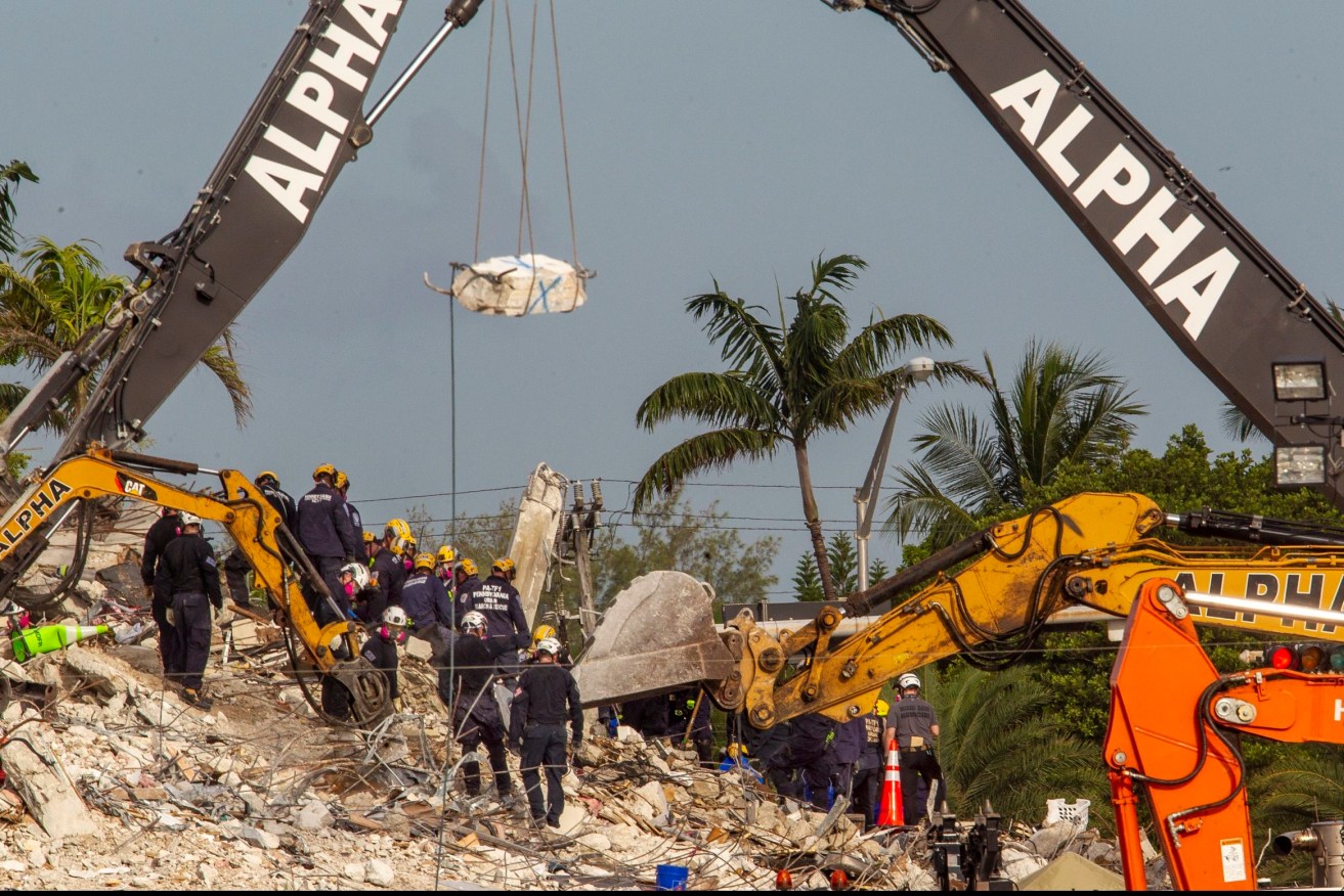 The search for victims at a collapsed South Florida condo building after demolition crews set off a string of explosives that brought down the last of the structure in a plume of dust on Sunday. (Pedro Portal/Miami Herald via AP)