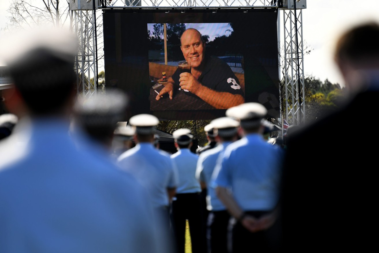 Queensland police officer Senior Constable David Masters has been farewelled with a helicopter escort and a guard of honour after he was killed in the line of duty last month. (AAP Image/Dan Peled) 