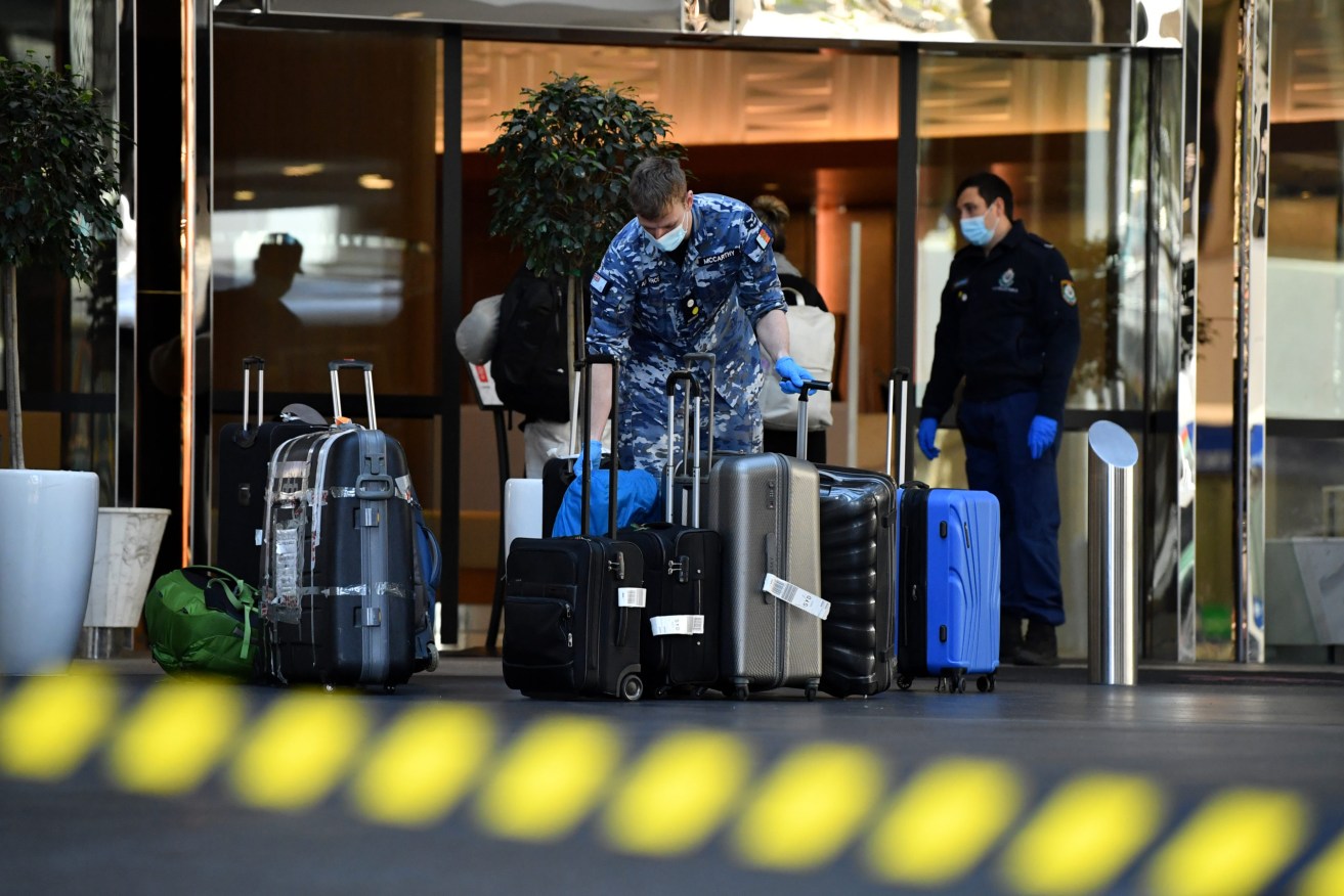 Defence Force personal carry bags at a quarantine hotel in the central business district in Sydney. The stay-at-home orders for coronavirus-hit Greater Sydney and surrounds have been tightened. (AAP Image/Joel Carrett) 