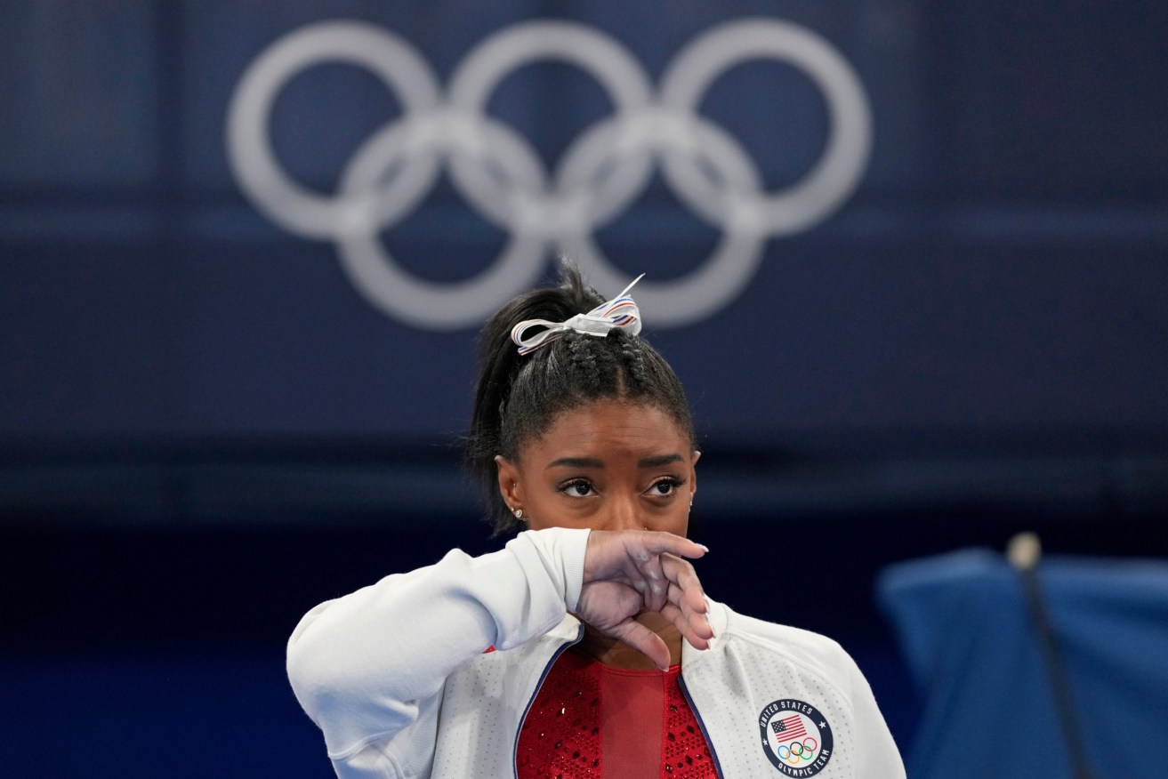 Simone Biles, of the United States, watches gymnasts perform at the 2020 Summer Olympics. Biles says she wasn't in right 'headspace' to compete and withdrew from gymnastics team final to protect herself. (AP Photo/Ashley Landis)