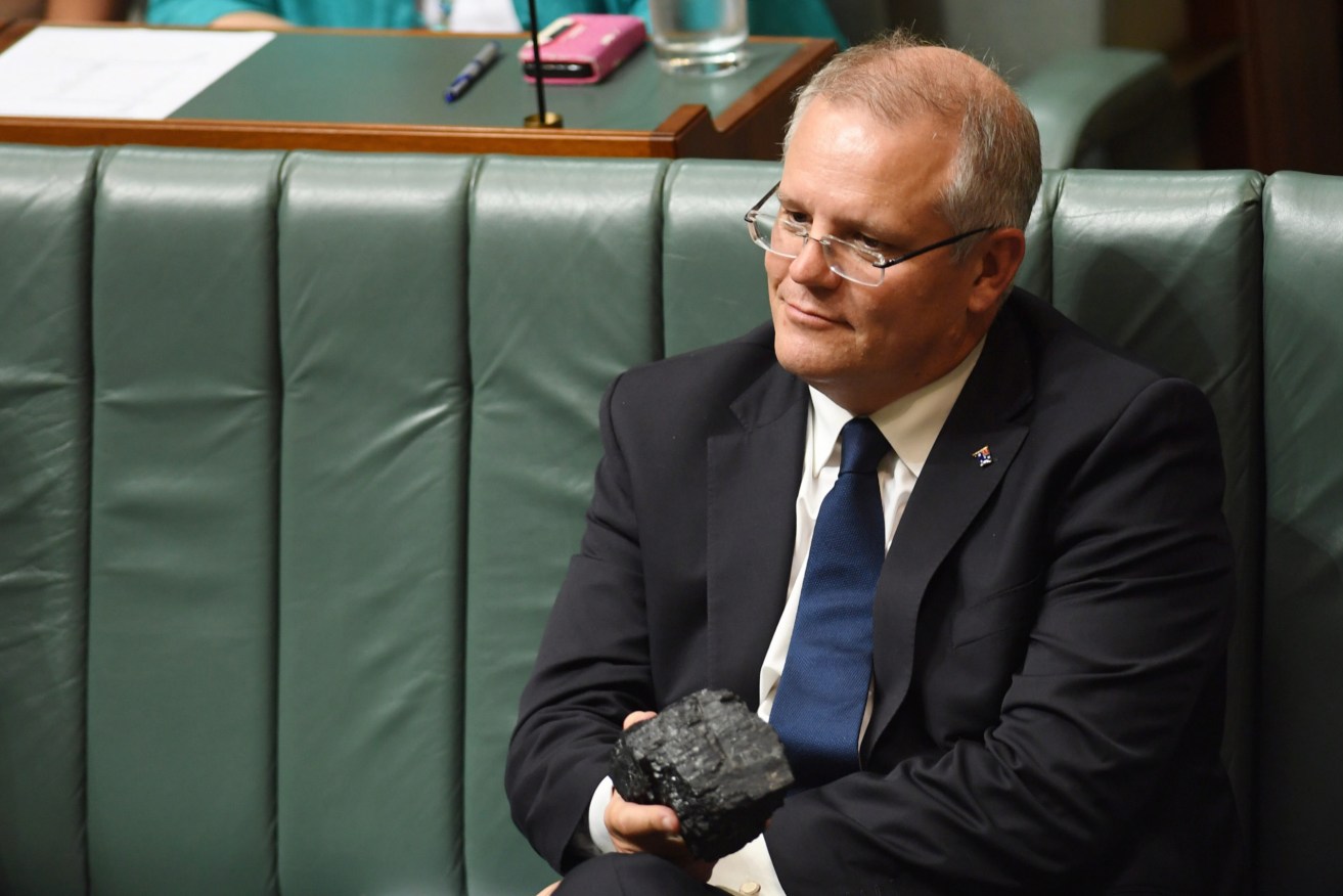 Scott Morrison with a piece of coal in the House of Representatives in 2017. A new report argues fossil fuel industries are are among those "distorting democratic processes to win political outcomes".(AAP Image/Lukas Coch) 