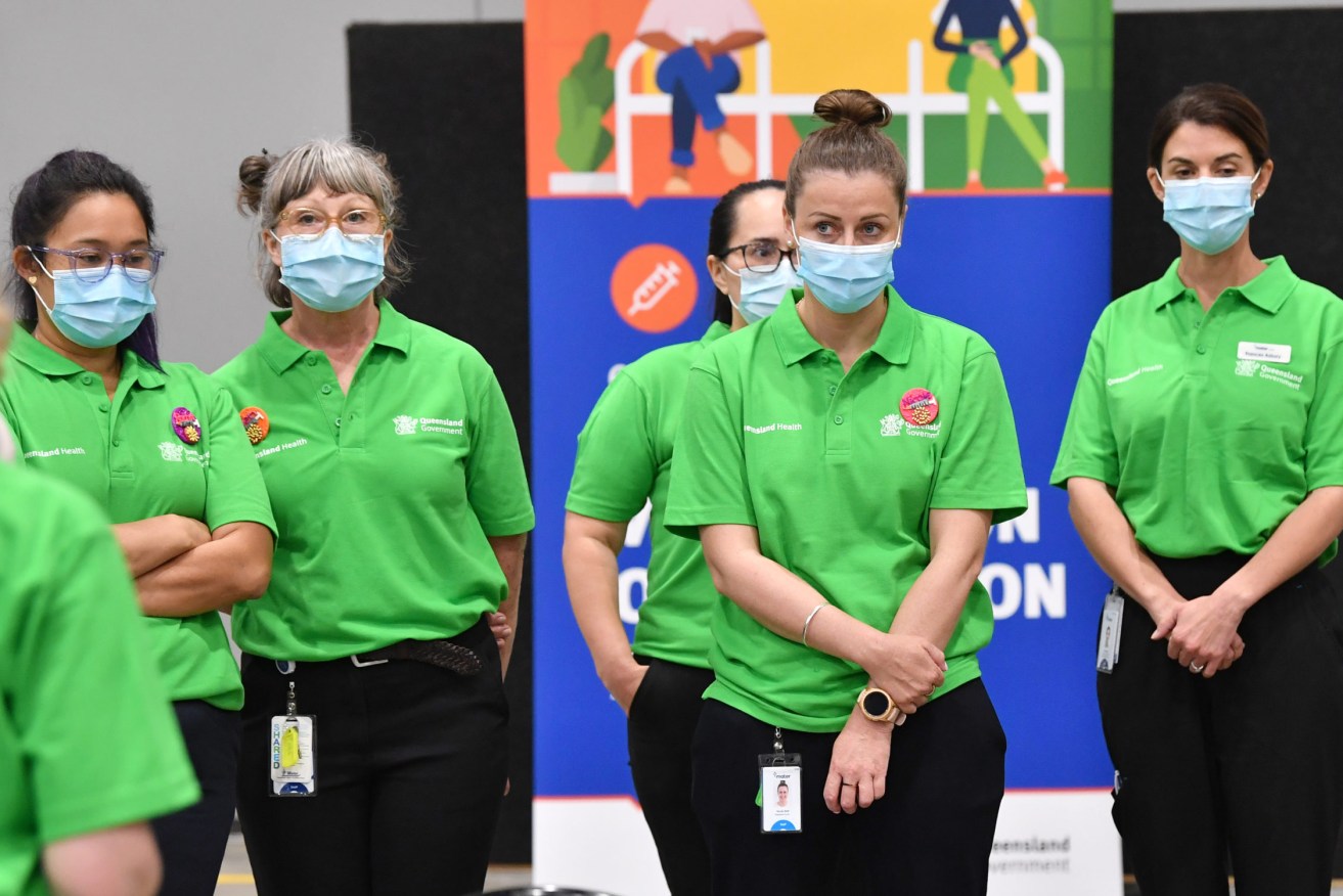 Staff are seen inside the mass COVID-19 vaccination centre at the Brisbane Convention and Exhibition Centre. (AAP Image/Darren England) 