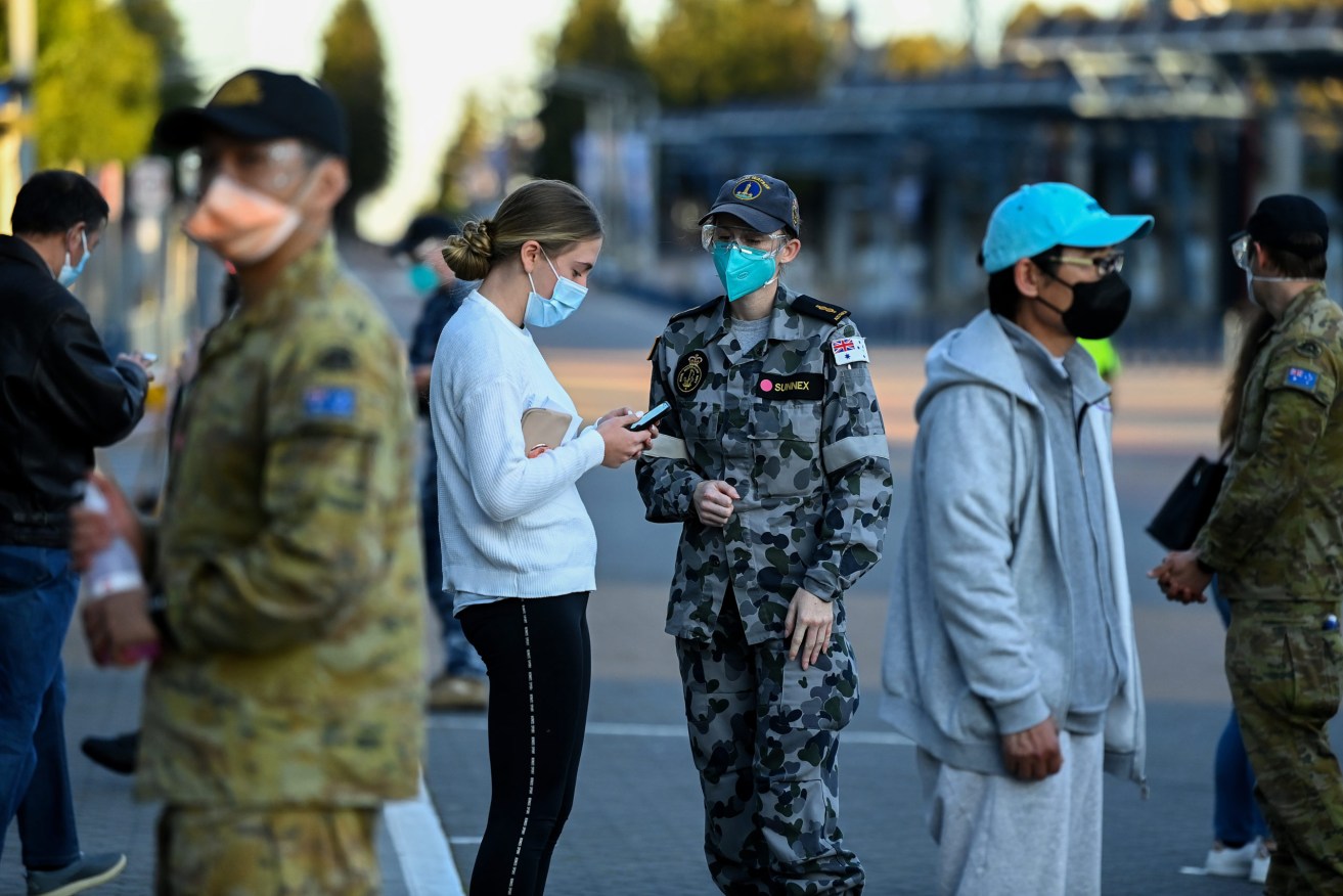 Australian Defence Force (ADF) personnel assist people as they check into the Qudos Bank Arena NSW Health COVID-19 Vaccination Centre in Sydney Monday, August 16. (AAP Image/Bianca De Marchi) 