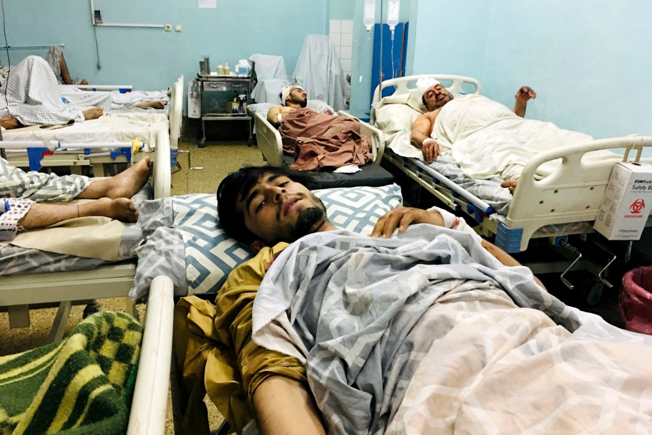 Wounded Afghans lie on a bed at a hospital after a deadly explosions outside the airport in Kabul, Afghanistan. Two suicide bombers and gunmen attacked crowds of Afghans flocking to Kabul's airport, transforming a scene of desperation into one of horror . (AP Photo/Mohammad Asif Khan)