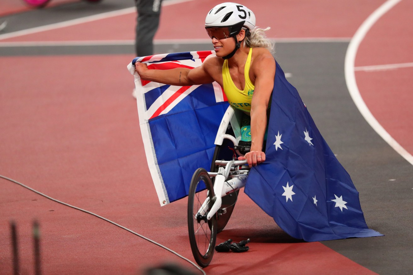 Madison de Rozario of Australia holds the Australian flag after finishing first and claiming gold in the Women’s 800m T53 Final event at the Olympic Stadium during the Tokyo Paralympic Games  (AAP Image/Paralympics Australia/Sport the Library/Drew Chislett) 