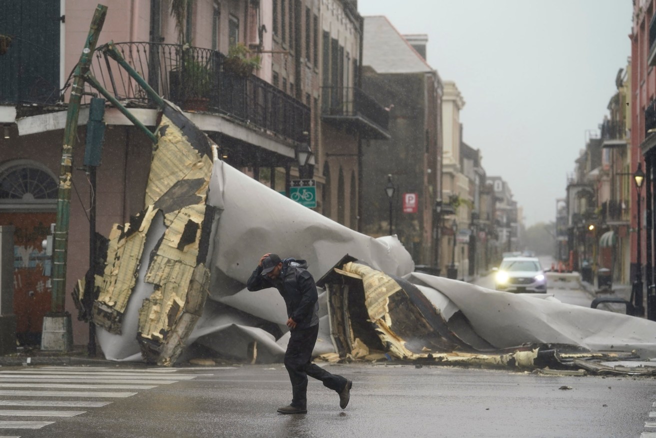 A man passes by a section of roof that was blown off of a building in the French Quarter by Hurricane Ida winds in New Orleans. (AP Photo/Eric Gay)